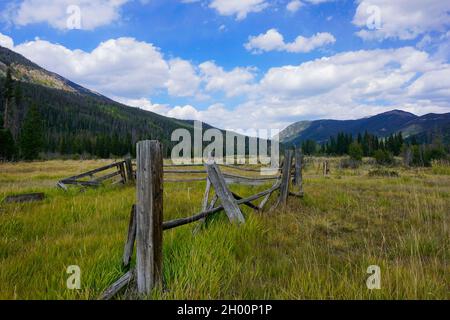 Blick auf das Tal im Herbst auf einen hölzernen geteilten Eisenbahnzaun im Rocky Mountain National Park Stockfoto