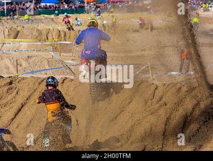 Weymouth, Dorset, Großbritannien. 10.. Oktober 2021. Tausende von Zuschauern strömen nach Weymouth, um den Reitern beim jährlichen Motocross-Rennen am Weymouth Beach zuzusehen. Etwa 300 Fahrer fahren mit hoher Geschwindigkeit und geschicktem Manövrieren um die Hindernisstrecke, während die Menschenmassen die Action beobachten, dem Dröhnen der Motoren und dem Geruch der Motorräder lauschen. . Kredit: Carolyn Jenkins/Alamy Live News Stockfoto