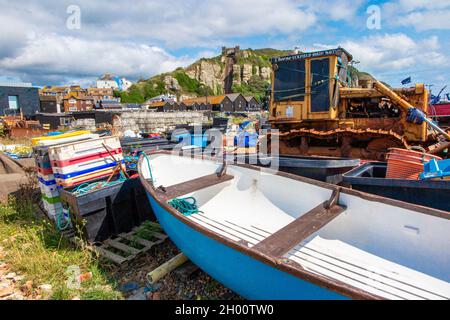 Fischerboote am Kiesstrand an der Küste von Hastings in East Sussex, England, mit der Standseilbahn in der Ferne Stockfoto