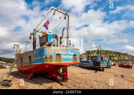 Fischerboote am Kiesstrand an der Küste von Hastings in East Sussex, England, mit der Standseilbahn in der Ferne Stockfoto