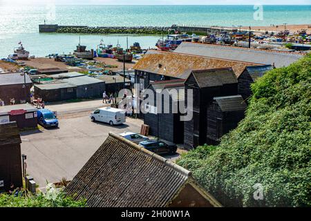 Blick auf die historischen Fischerhütten und Boote an der Küste von Hastings in East Sussex, England Stockfoto