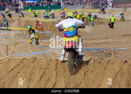 Weymouth, Dorset, Großbritannien. 10.. Oktober 2021. Tausende von Zuschauern strömen nach Weymouth, um den Reitern beim jährlichen Motocross-Rennen am Weymouth Beach zuzusehen. Etwa 300 Fahrer fahren mit hoher Geschwindigkeit und geschicktem Manövrieren um die Hindernisstrecke, während die Menschenmassen die Action beobachten, dem Dröhnen der Motoren und dem Geruch der Motorräder lauschen. . Kredit: Carolyn Jenkins/Alamy Live News Stockfoto