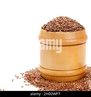 Leinsamen in einem Holzkrug isoliert auf weißem Hintergrund. Ort für Ihren Text. Stockfoto