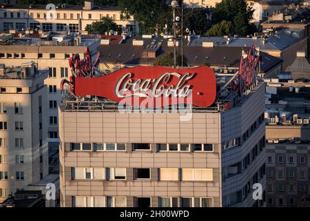 Coca Cola klassisches Vintage Neonschild bei Sonnenuntergang auf dem Wohnturm in der Innenstadt von Warschau in Polen. Stockfoto