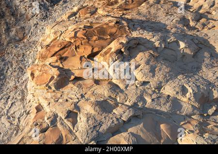 Felsformation an der Küste von Dschanhot (Russland) Nahaufnahme. Textur, Hintergrundschichten und Risse im Sedimentgestein an der Felswand. Felsschiefer in der Stockfoto