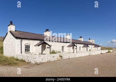 Llanddwyn, Wales: Pilotenhaus, eine Reihe von vier traditionellen Hütten, die vor 1830 für die Leuchtturmwärter, Piloten und Rettungsboa gebaut wurden Stockfoto