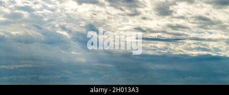 Blick auf die dichten Wolken, die die Himmel bedecken und durch die Sonnenstrahlen ragen Stockfoto