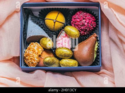 Echte frische, bunte Designer-Schokolade in der Schachtel für gute Laune Stockfoto