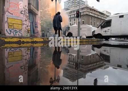 Santiago, Metropolitana, Chile. Oktober 2021. Ein Mann geht eine Straße im Zentrum von Santiago entlang, wo es zu gewalttätigen Zusammenstößen zwischen Polizei und Demonstranten kommt, mitten in einem Protest zum Tag des Rennens in Santiago, Chile. 10. Oktober 2021. (Bild: © Matias Basualdo/ZUMA Press Wire) Stockfoto