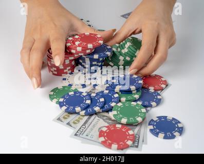 Hände schieben Stack-Chips nach vorne zum Wetten. Spielchips und Geld auf weißem Hintergrund. Alles in Las vegas zu verlieren. Stockfoto