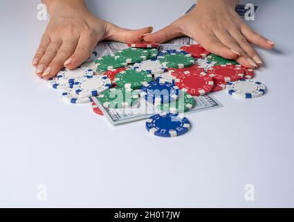 Hände schieben Stack-Chips nach vorne zum Wetten. Spielchips und Geld auf weißem Hintergrund. Habe alles in Las vegas gewonnen. Stockfoto