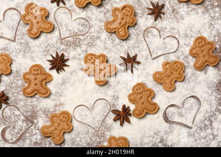 Ein farbenfrohes fröhliches Muster aus ungebackenen Lebkuchenkeksen, Sternanisfrüchten und Samen sowie herzförmigen Markierungen auf der Küchenarbeitsplätzchen. Stockfoto