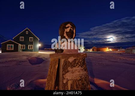 Schneebedeckte Statue von Amundsen in der dunklen Jahreszeit auf Spitzbergen. Ny Ålesund, Svalbard, Norwegen Stockfoto