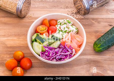 Veganer Sack mit gewürfeltem Tofu, Rotkohl, Gurke, Kirschtomaten, Schnittlauch und Ginseng Stockfoto