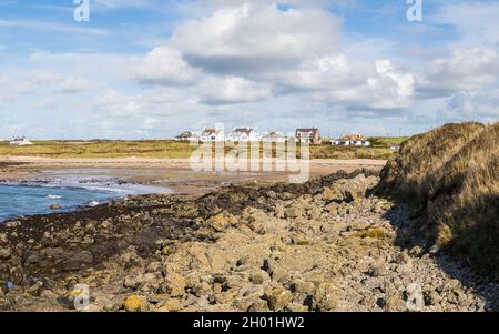 Häuser blicken auf Porth Trecastell an der Küste von Anglesey in Nordwales, gesehen im Oktober 2021. Stockfoto