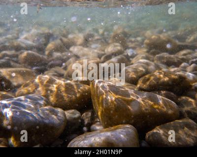 Kieselsteine steinigen unter der Wasseroberfläche in der Nähe des Seeufers, natürliche Szene, Nahaufnahme Stockfoto