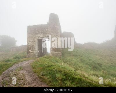 Haupteingang in den Rest der Ruine der Festung Lichnice bei starkem Nebel und bewölktem regnerischen Tag. Tschechien Reise. Stockfoto