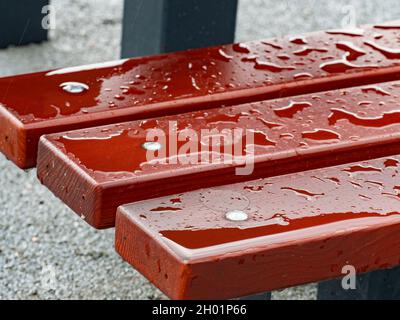 Regentropfen auf einer Bank, nasse Holzbretter. Detail aus poliertem Holz Stockfoto