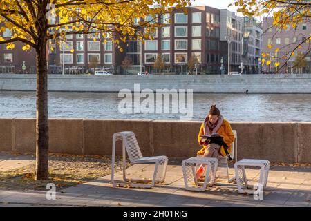 Moskau, Russland. 10. Oktober 2021 An einem sonnigen Herbsttag in Moskau, Russland, Liest Eine Frau ein Buch über den Krim-Damm im Muzeon-Park Stockfoto