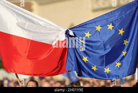 Die Flaggen der Europäischen Union und Polens werden von Menschen zusammengebunden, die bei einer massiven öffentlichen Demonstration zur Unterstützung der Mitgliedschaft Polens in der EU protestieren Stockfoto