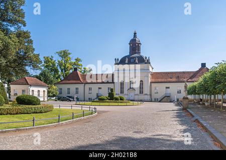 Berlin, Deutschland - 6. September 2021: Schlosskirche des barocken Wasserschlosses Schloss Köpenick mit den flankierenden ehemaligen Wirtschaftsflügeln und den geschwungenen Stockfoto