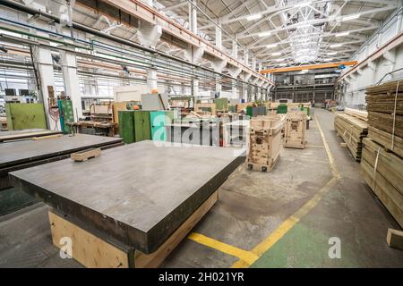 In der inneren Werkshalle mit Holzstapeln für die Herstellung von Formen und Schreinerei Werkzeugmaschinen. Stockfoto