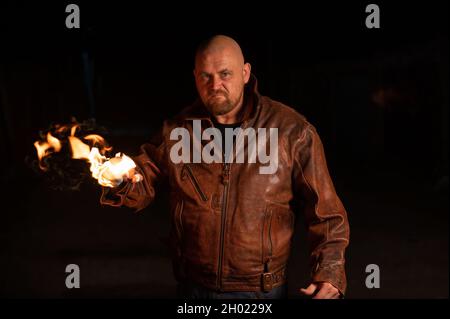 Der kahlköpfige Kaukasusmann schlägt mit brennender Faust. Stockfoto