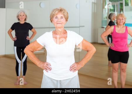 Porträt einer reifen Frau, die zu Beginn der Klasse ein Warm-up macht Stockfoto