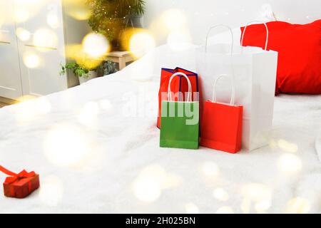 Weihnachts-Shopping-Konzept mit Papiertüten und Geschenkbox auf dem Bett zu Hause Stockfoto