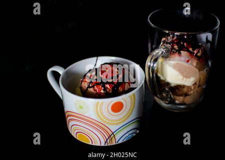 Leckeres Eis mit Rahm, Rosinen und Schokoladenstückchen in der Tasse auf dem Tisch. Salvador, Bahia, Brasilien. Stockfoto