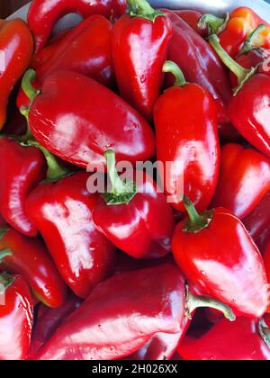 Eine vertikale Aufnahme von frischen roten Paprika unter den Lichtern Stockfoto