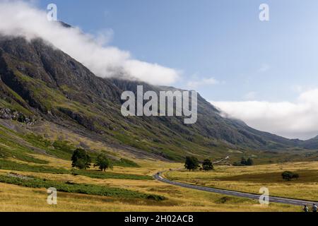 Wolken hängen über den Berggipfeln im wunderschönen Glencoe-Tal im schottischen Hochland Stockfoto