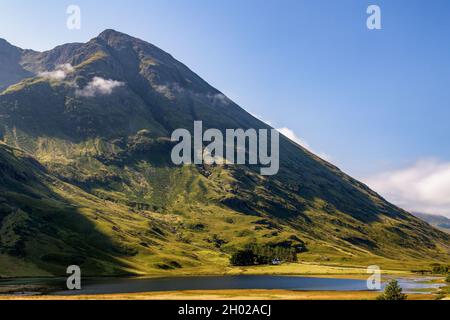 Wolken hängen über den Berggipfeln im wunderschönen Glencoe-Tal im schottischen Hochland Stockfoto