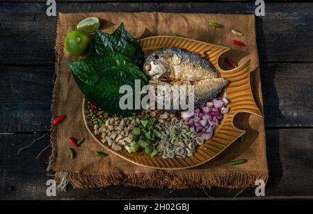 Traditionelle thailändische Essen: Gebratene Makrele serviert mit frischem Gemüse und Kraut, das Essen ist das thailändische Essen call Meuang Makrele (Maing-Pla-zu). Stockfoto