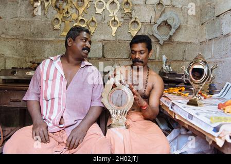 Aranmula, Indien - 5. Dezember 2015: Kerala. Silber Spiegel handgemachte Produktion in ländlichen Gebieten, macht der Mensch handgefertigte einzigartige Kunstwerke. Familie klein Stockfoto