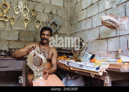 Aranmula, Indien - 5. Dezember 2015: Kerala, silberne Spiegel handgefertigte Produktion in ländlicher Umgebung, macht der Mensch handgefertigte einzigartige Kunstwerke. Familie klein Stockfoto