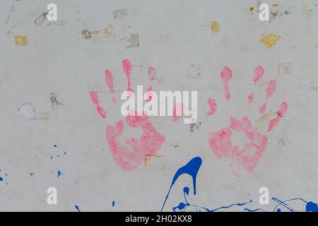 Rote Handdrucke auf weißem Vintage-Wandhintergrund Stockfoto