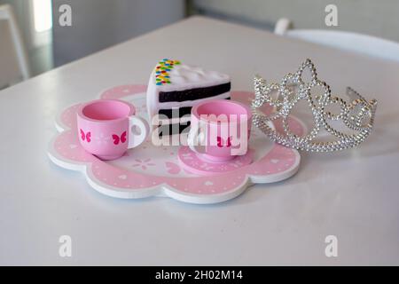 Was ist besser, als Tee und Plastikkuchen vorzutäuschen? Fantasie macht diese besondere Tee-Party fit für eine Prinzessin. Inklusive Tiara. Stockfoto