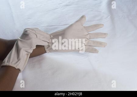 Handtragende Einweg-Handschuhe auf weißem Hintergrund. High-Angle-Ansicht. Nahaufnahme. Verwendung und Schutz der Handhygiene zur Reduzierung des Keimrisikos spr Stockfoto