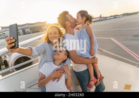 Glückliche Familie, die auf einer Leiterebene steht und auf Reisen geht Stockfoto