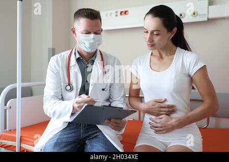 Der Arzt führt die ärztliche Untersuchung der Patientin in der Klinik durch Stockfoto