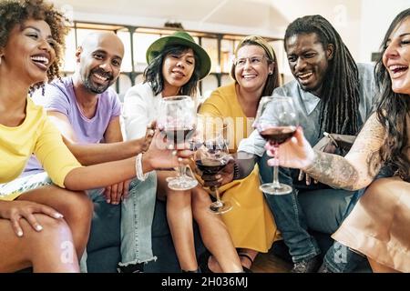 Gruppe von Freunden, die sich vor dem Abendessen auf der Party Vergnügen Aperitif-Buffet, Cocktails trinken und Snacks essen - Junge Leute verbringen Zeit zusammen zu Hause - B Stockfoto