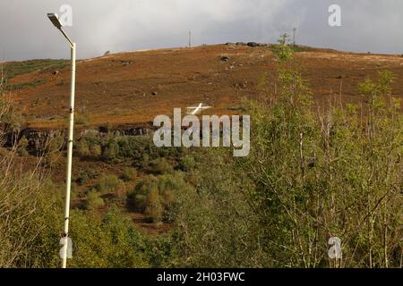 Hoch oben auf dem Hügel liegen die großen weiß gestrichenen Felsen, die an der Seite angeordnet sind und einen klaren Blick von der Stadt unten geben. Stockfoto