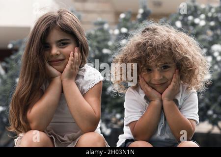 Portrait von glücklichen Kindern, die im Park sitzen. Kleiner Bruder und Schwester verbringen gerne Zeit miteinander. Beste Freunde Für Immer. Stockfoto