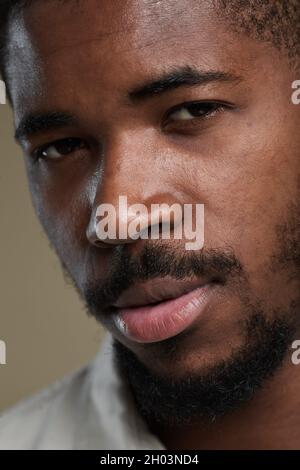 Extreme Nahaufnahme des hübschen afroamerikanischen Mannes, der die Kamera anschaut Stockfoto