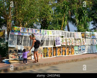 Luang Phrabang, Laos - 4. Februar 2020. Touristen kaufen Gemälde auf der Straße in Luang Phrabang, Laos. Die Stadt war die Hauptstadt des Königreichs La Stockfoto