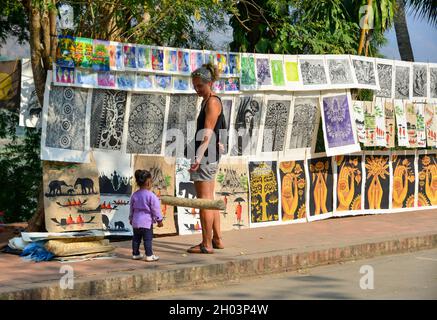 Luang Phrabang, Laos - 4. Februar 2020. Touristen kaufen Gemälde auf der Straße in Luang Phrabang, Laos. Die Stadt war die Hauptstadt des Königreichs La Stockfoto