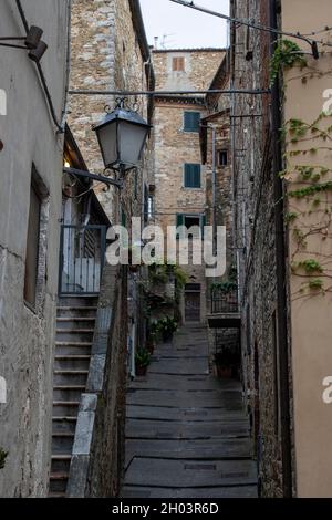 Eine dünne, nasse italienische Kopfsteinpflasterstraße in einer Stadt auf einem Hügel in Italien Stockfoto