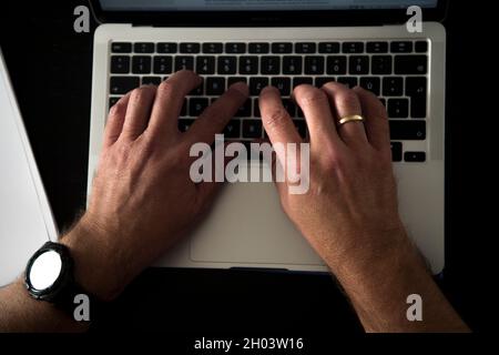 München, Deutschland. Oktober 2021. Ein Mann sitzt zu Hause an einem Esstisch und arbeitet an einem Laptop. (Posed Scene) (zur dpa „Präsentation des DKV-Berichts 2021 „wie gesund ist Deutschland?“) Quelle: Finn Winkler/dpa/Alamy Live News Stockfoto