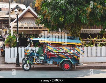 Luang Phrabang, Laos - 4. Februar 2020. Tuk Tuk wartet auf Touristen in Luang Phrabang, Laos. Die Stadt war bis 1975 die Hauptstadt des Königreichs Laos. Stockfoto